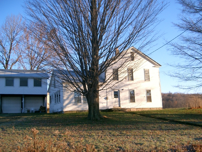 A view from the road of the primary elevation of the house.   New exterior walls