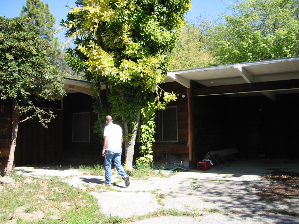 The client walking toward the entry at the rear of the house, by the open garage