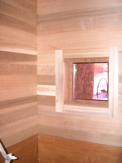 Interior corner of seating area with view out small window facing west.