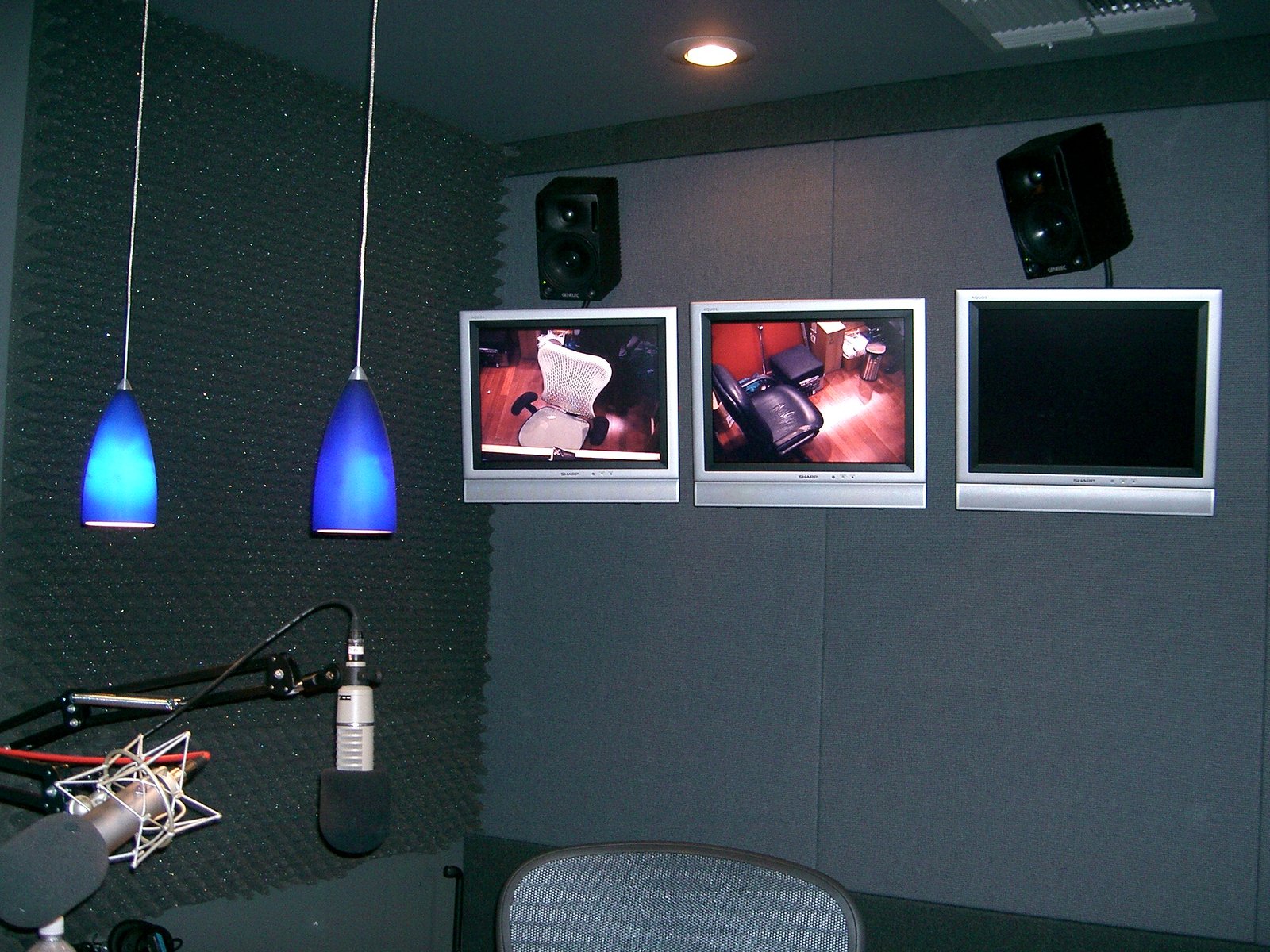 The recording studio space, with the LCD monitors of the control room.