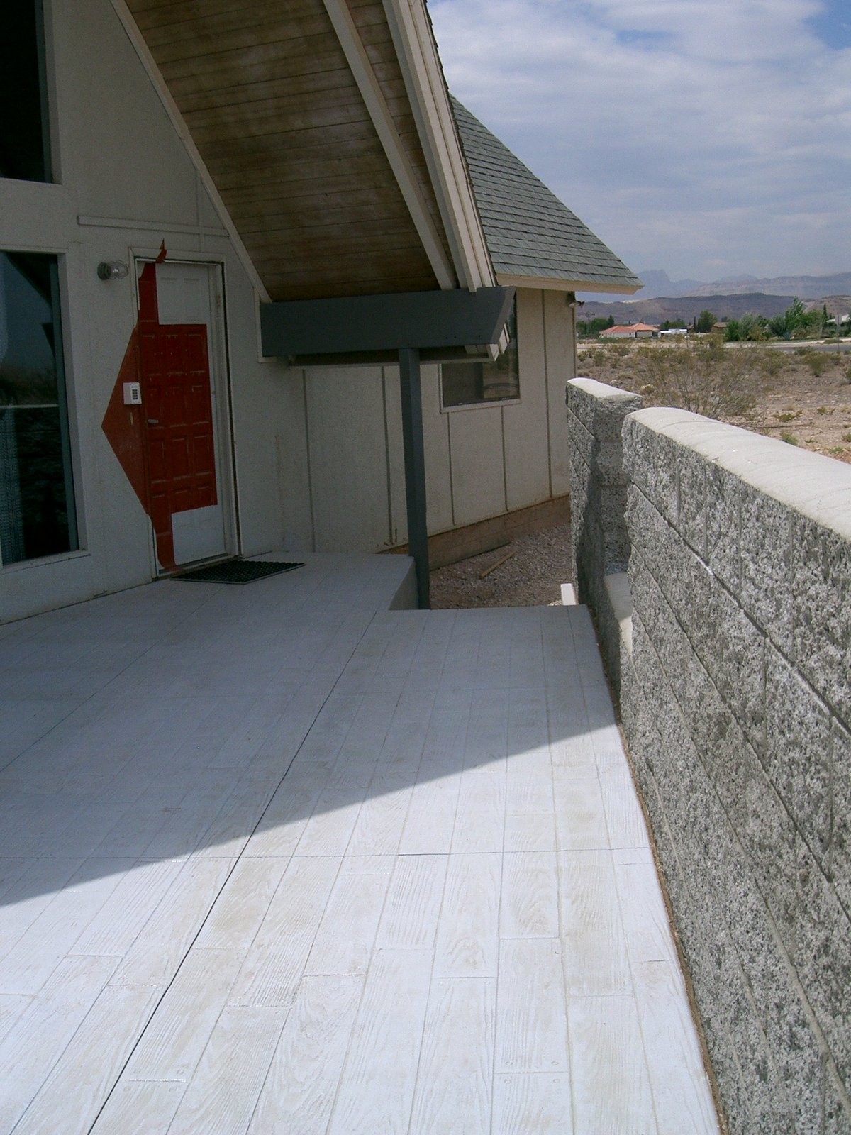 The grey-stained concrete of the terrace is stamped with a pattern of wooden pla