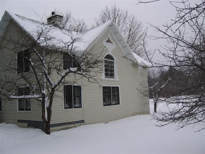 The north facade has this decorative window on the second floor. (The vinyl sidi